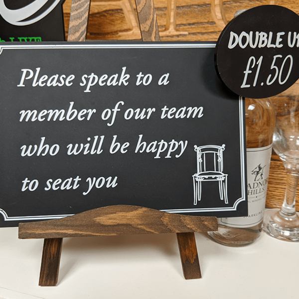 small chalkboard sitting on an easel for reserved seating in a restaurant
